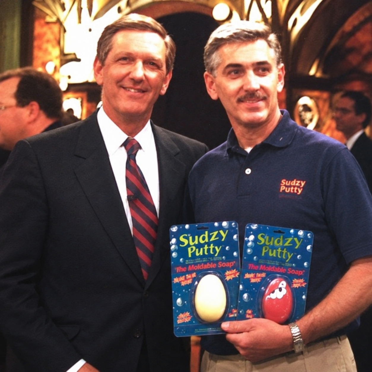 Historical photograph of two men with Sudzy Putty product packages, digitally restored from the original photograph